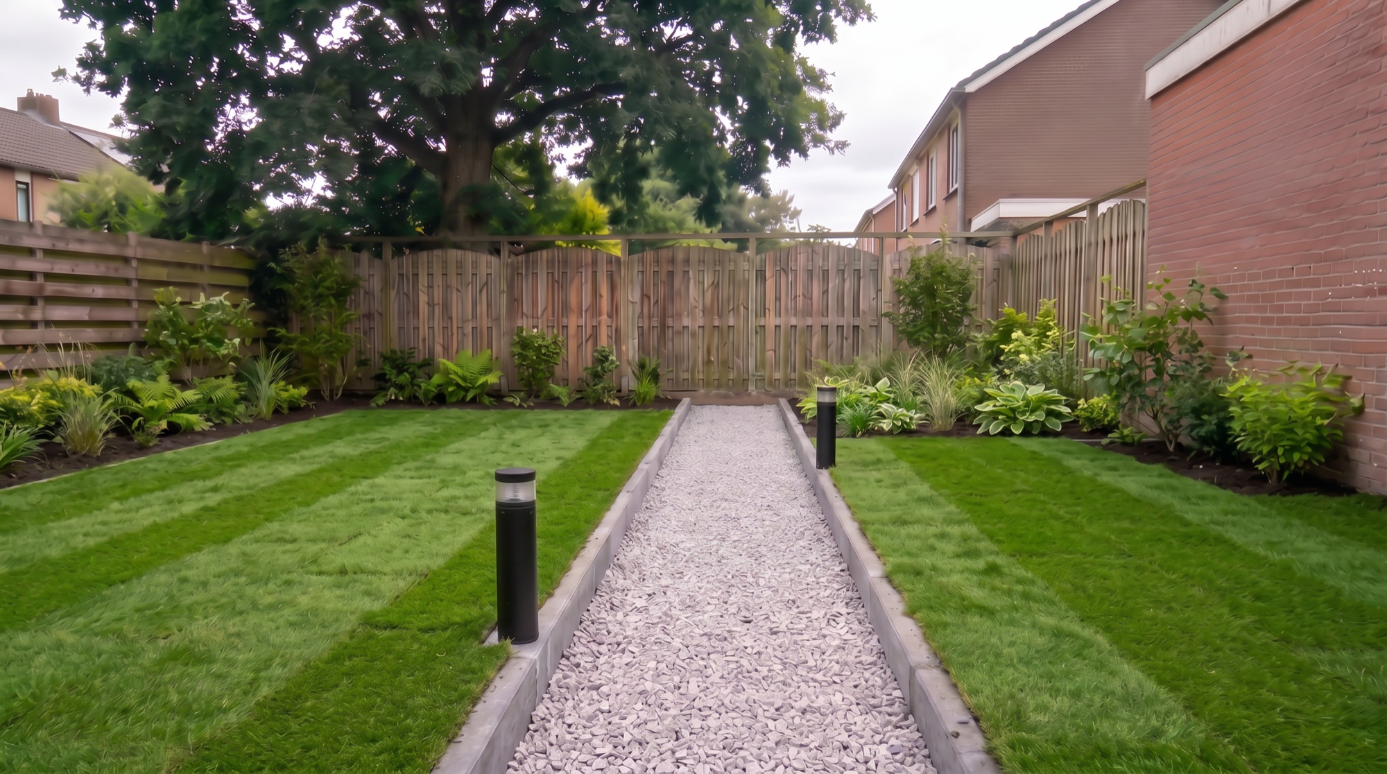 The finished garden a season on — striped lawn, lush borders and a settled gravel path